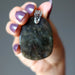 hand holding large labradorite pendant