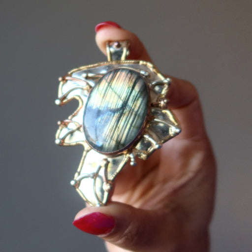 hand holding labradorite pendant