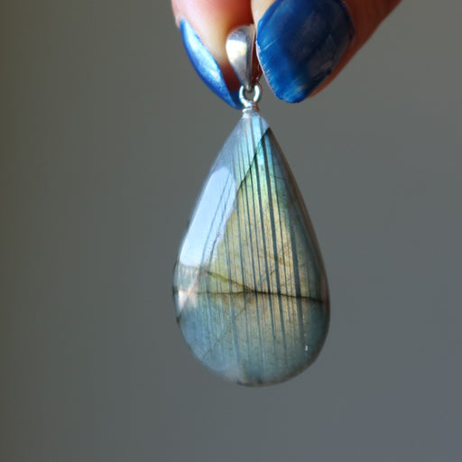 hand holding labradorite teardrop pendant
