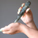 hand holding labradorite massage wand massaging wrist