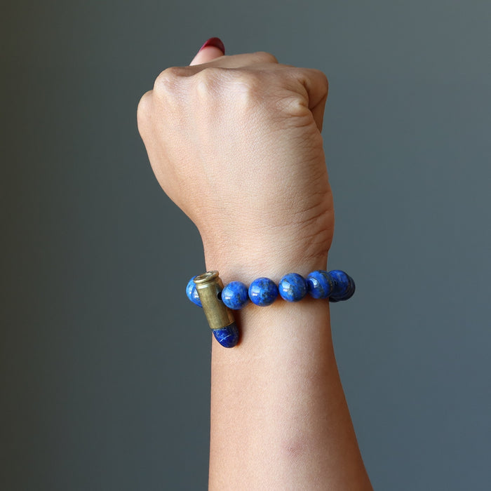 hand making a fist wearing a lapis peace bullet stretch bracelet