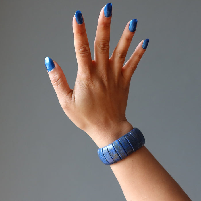 hand wearing a chunky lapis lazuli stretch cuff bracelet