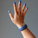 hand wearing a chunky lapis lazuli stretch cuff bracelet