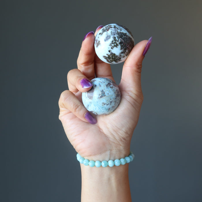 hand holding larimar spheres wearing larimar bracelet