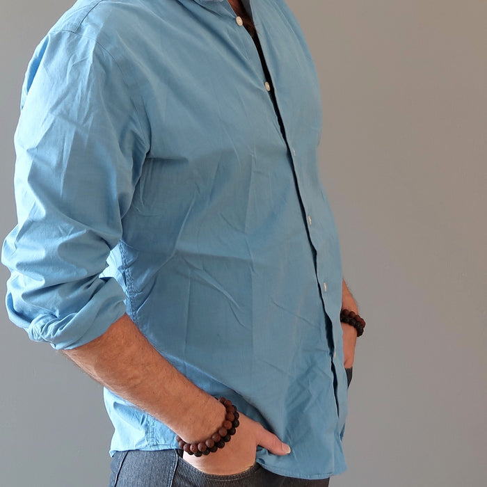 man's hand in pockets wearing red and black lava bracelets