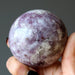 hand holding quartz lepidolite sphere