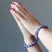 clasped hands wearing lepidolite bracelets