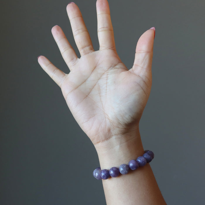 hand wearing purple lepidolite bracelet