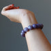 hand wearing purple lepidolite bracelet