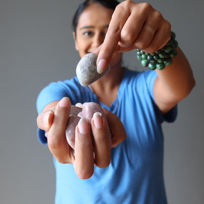 woman holding purple lepidolite tumbled stones