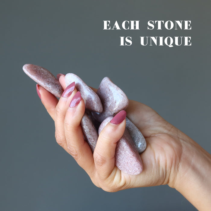 purple lepidolite tumbled stones in hand