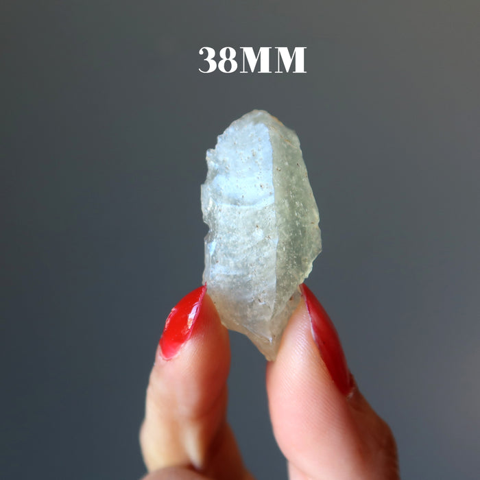 hand holding up a 38mm libyan desert glass raw tektite