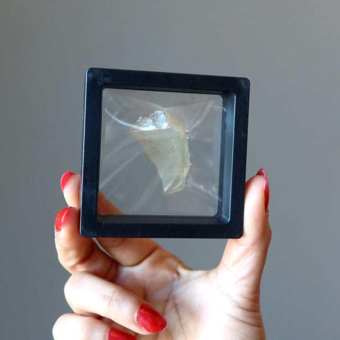 hand holding libyan desert glass in a floating case