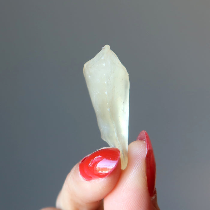 fingers holding up a libyan desert glass