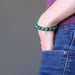 woman's hand in pants pocket wearing green malachite stretch bracelet