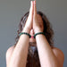 aleks of satin crystals with hands in meditation wearing malachite bracelets on each wrist