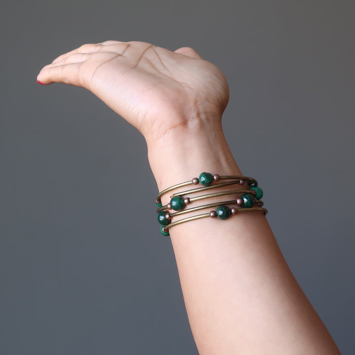 A woman's hand and arm showing off the Malachite vintage coil bracelet