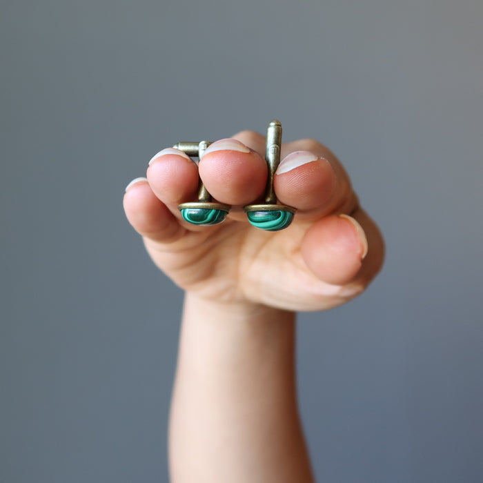 hands holding malachite cufflinks
