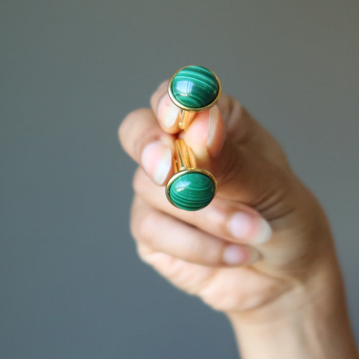 hand holding gold malachite cufflinks