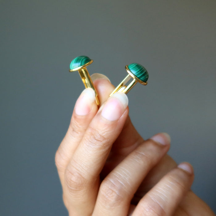 hand holding gold malachite cufflinks