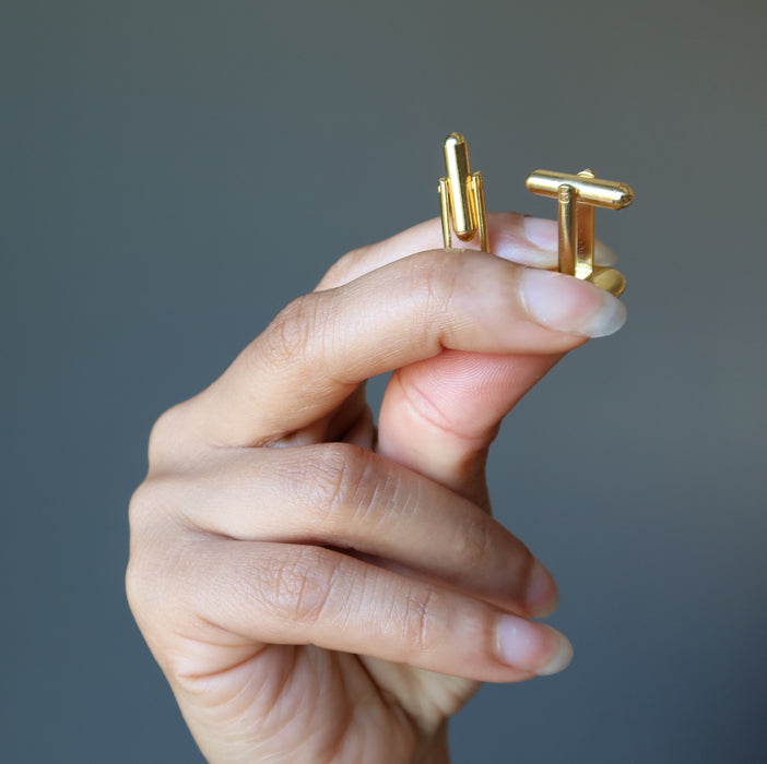 hand holding gold malachite cufflinks