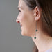 woman wearing long malachite dangle earrings