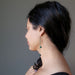 woman wearing long malachite dangle earrings
