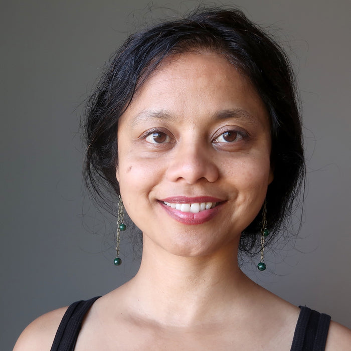 woman wearing long malachite dangle earrings