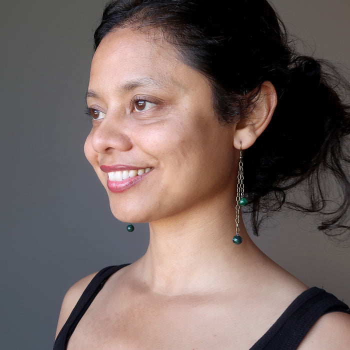 woman wearing long malachite dangle earrings