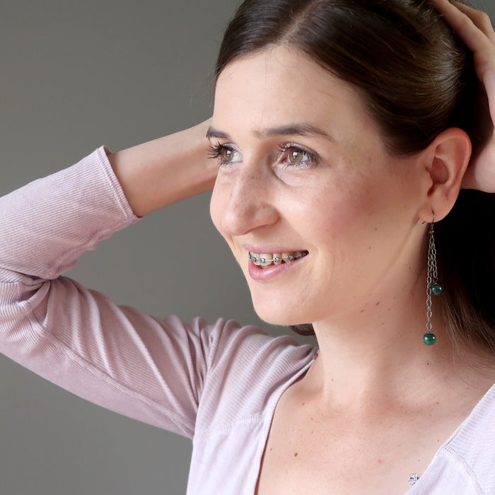 woman wearing long malachite dangle earrings