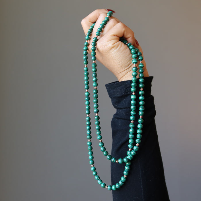 hand holding double strand malachite necklace