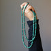 hand holding double strand malachite necklace