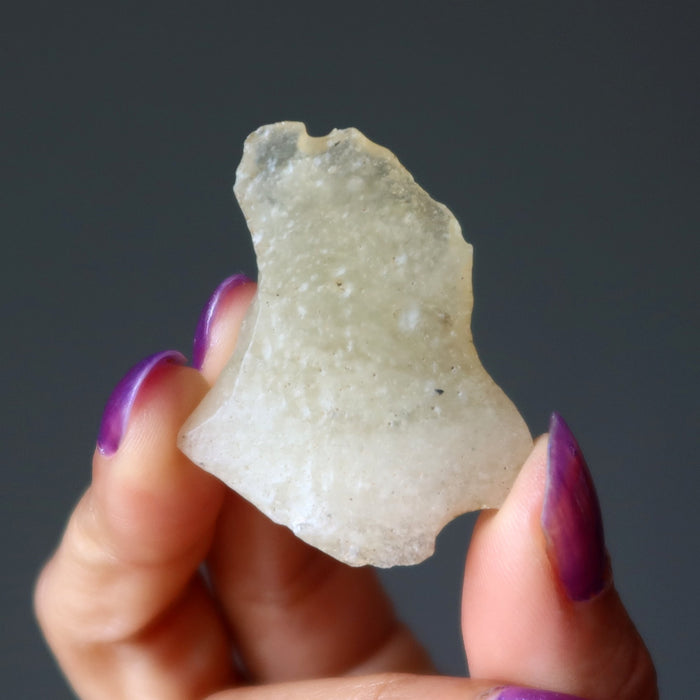 hand holding yellow libyan desert glass rough tektite