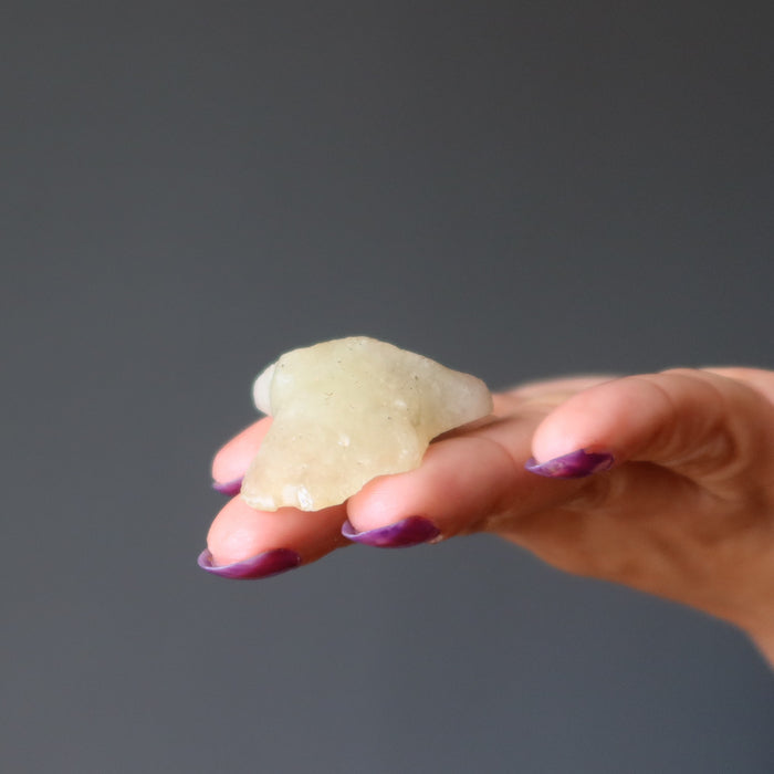 hand holding yellow libyan desert glass rough tektite