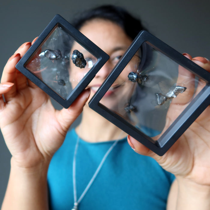 sheila of satin crystals holding meteorites in suspension frames