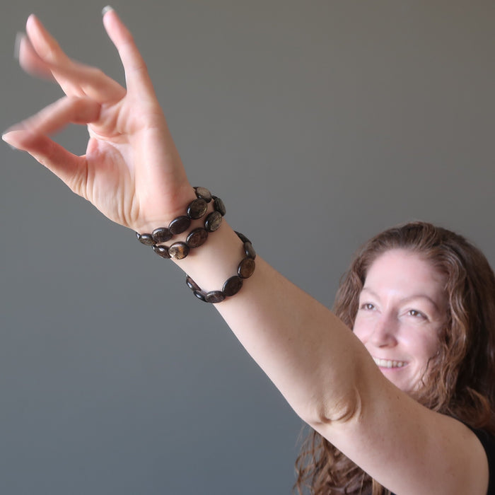 female model Jamie of Satin Crystals wearing 3 mica oval bracelets with hand up