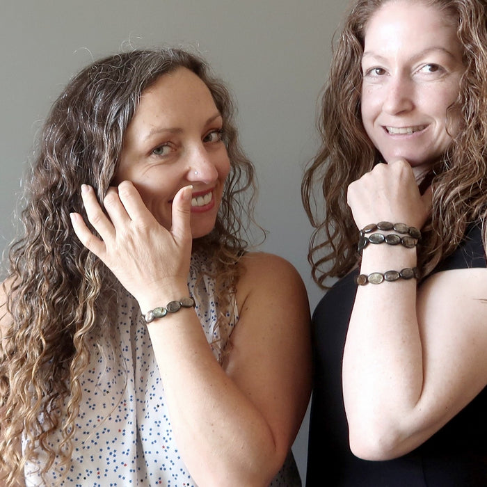 two female satin crystals models wearing female hand wearing mica oval stretch bracelets