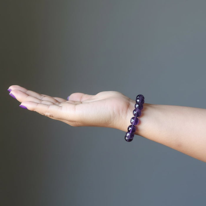 female hand wearing amethyst bracelet 