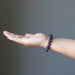 female hand wearing amethyst bracelet 