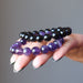 female hand with black tourmaline and amethyst bracelet set in palm