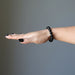 female hand wearing black tourmaline bracelet