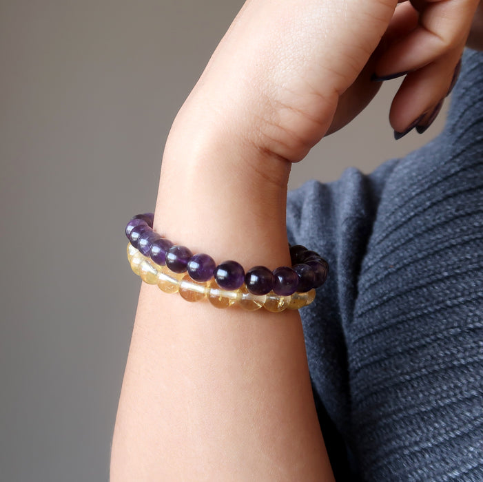 female hand modeling amethyst and citrine bracelet set