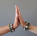 female hands palm to palm both modeling tourmaline quartz and serpentine bracelet sets