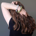 female hand with hand in hair modeling tourmaline quartz and serpentine bracelet set