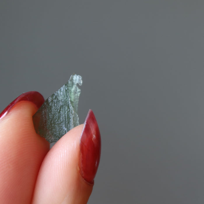 hand holding up a moldavite