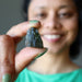 sheila of satin crystals gazing at a moldavite stone