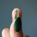hand holding rough green moldavite gemstone