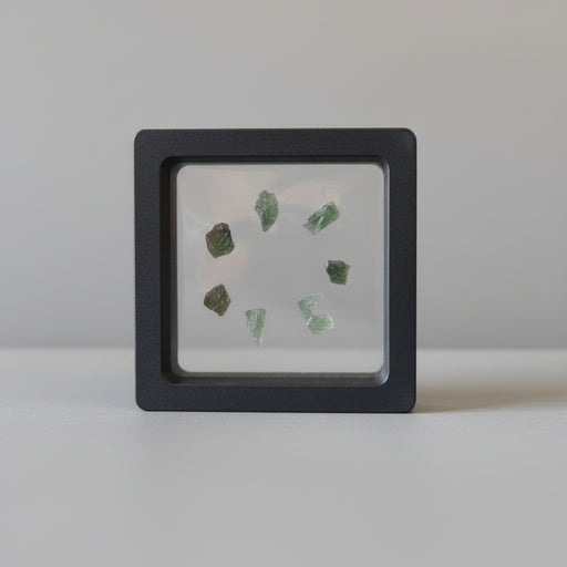 7 green raw moldavite tektites in suspension display case