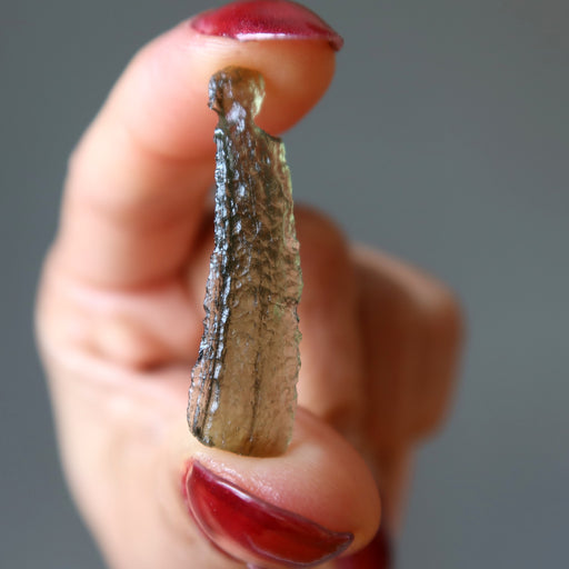 hand holding genuine moldavite gemstone