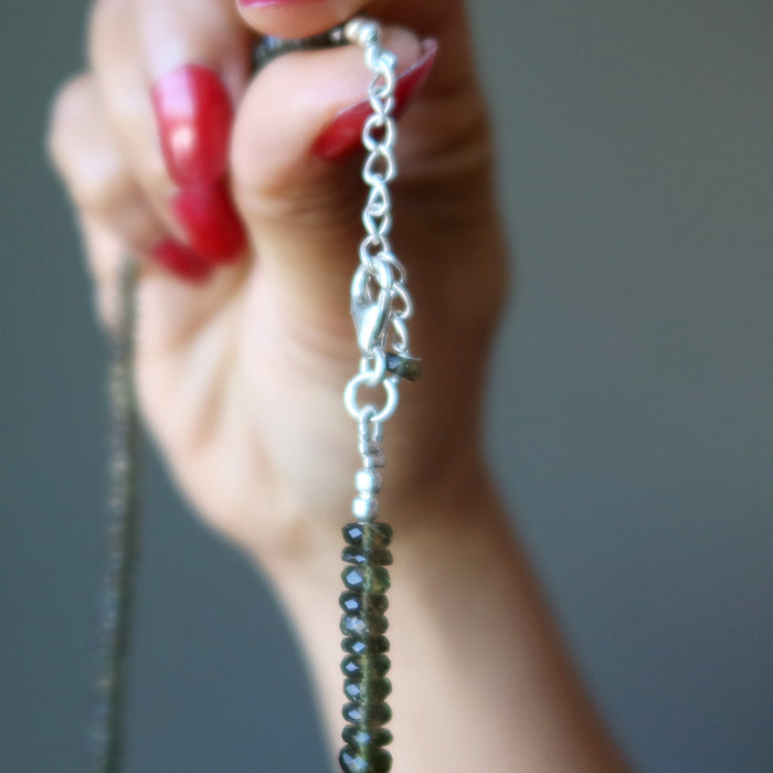 hand holding up moldavite necklace showing lobster claw clasp